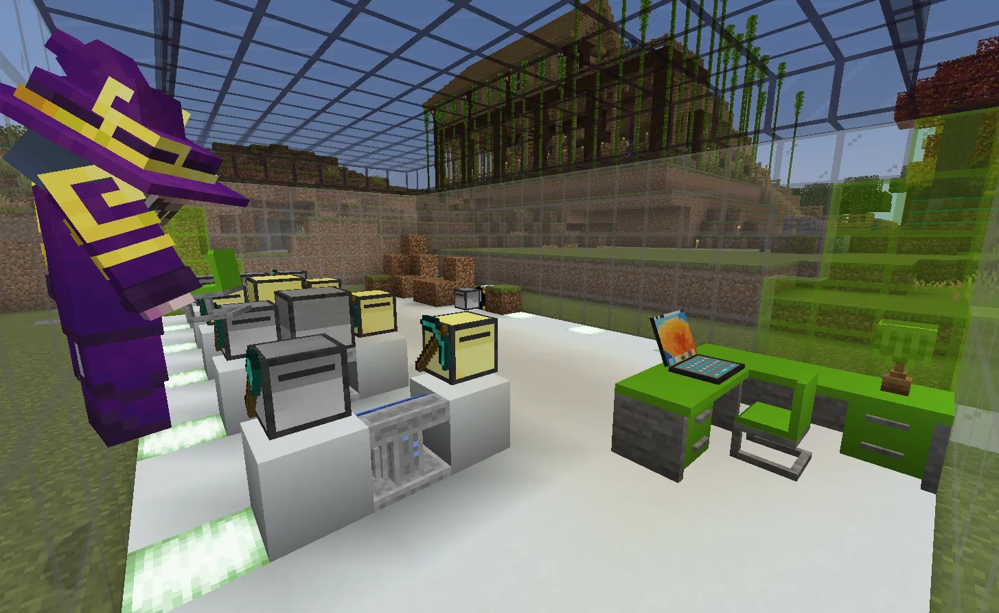 A figure in a purple and gold robe and pointed hat at the edge of a bright glass-roofed room under construction, with computers on white plinths, a green desk and chair, and stacked dirt blocks on the floor